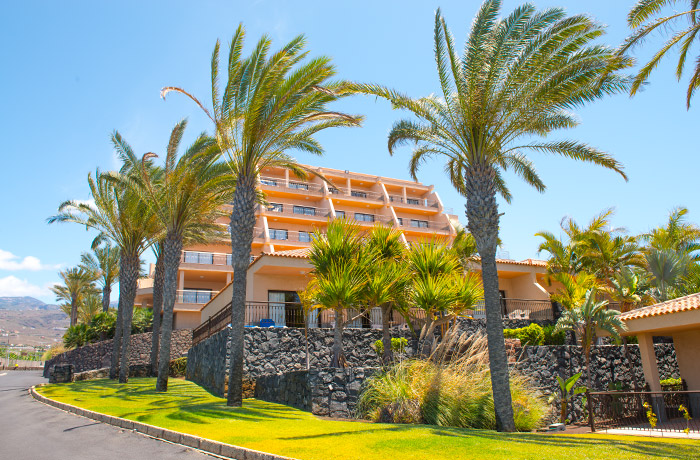 Jardin con cesped y palmeras de las villas del Hotel Dunas Paraiso en Los Cristianos, Arona