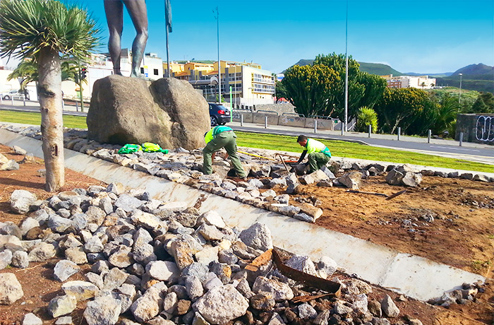 Trabajadores de interjardin colocando piedras en un jardin de la rotonda del Museo del Cosmos ubicada en la avenida de los Menceyes